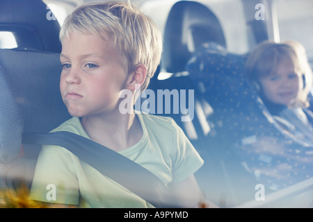 Due bambini seduti nel retro della macchina Foto Stock