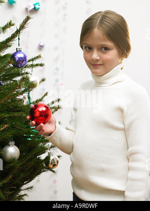 Ragazza giovane decorare albero di natale Foto Stock