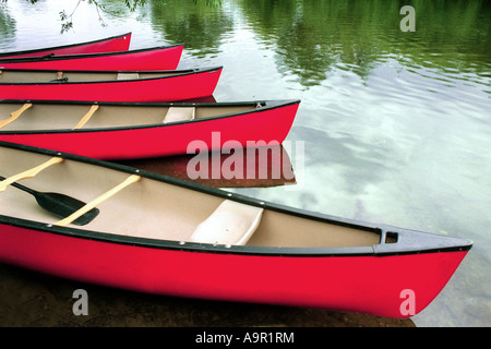 Red barche su una lenta scorre il fiume riflettente. Foto Stock