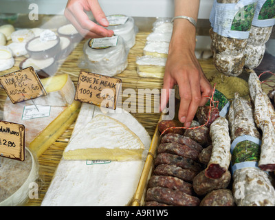 Donna di raggiungere nel display di delicatessen Foto Stock