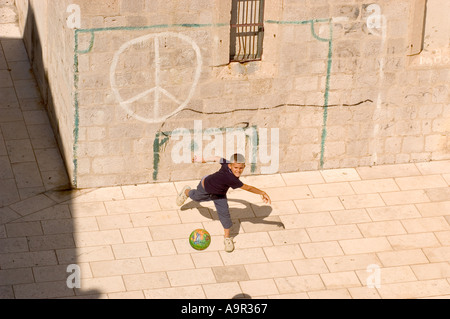 Ragazzo gettando la sfera dal traguardo di fortuna tracciata sulla parete Dubrovnik Croazia Foto Stock