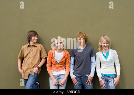 Quattro adolescenti appoggiata contro la parete Foto Stock