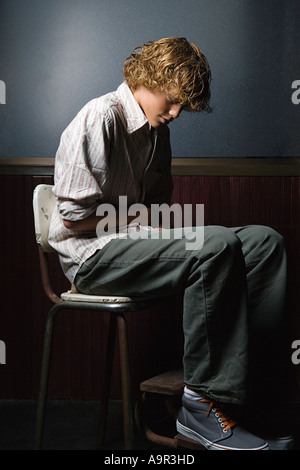 Ragazzo adolescente seduto da solo Foto Stock