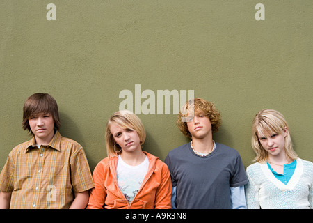 Quattro adolescenti appoggiata contro la parete Foto Stock