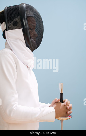 Ragazzo in abito di scherma con la spada Foto Stock