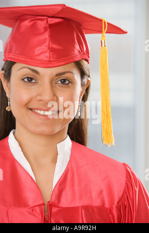 Donna indiana che indossa il cappuccio di graduazione e vestaglia Foto Stock