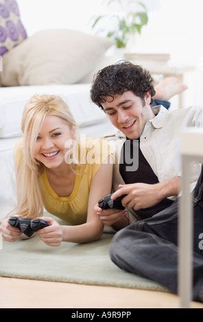Paio di giocare con i videogiochi su pavimento Foto Stock