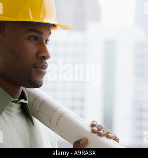 Uomo in hard hat holding blueprints Foto Stock