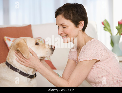 Donna petting cane nel livingroom Foto Stock