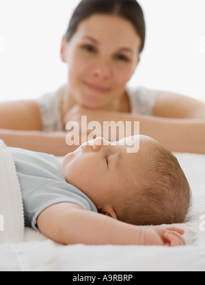 Madre guarda il sonno del bambino Foto Stock
