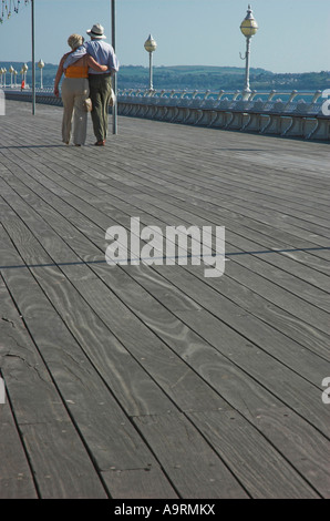 Un amore felice coppia di anziani camminare insieme su un molo sul mare. Foto Stock