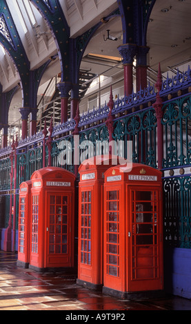 Rosso classico British le cabine telefoniche pubbliche permanente sulla Grand Avenue sotto gli archi di Smithfield Market, City of London Foto Stock