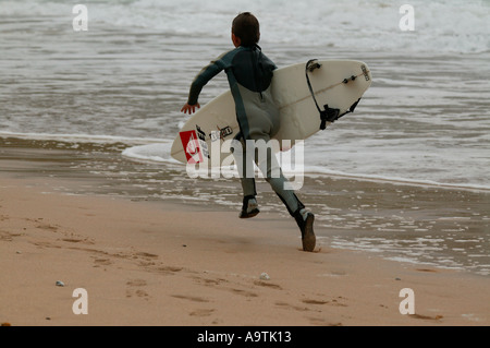 Giovani surfer, corse lungo la spiaggia, portando, tavola da surf, surf, acqua, mare, sport, esercizio Foto Stock