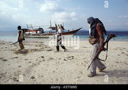 La ciurma del pirata a piedi lungo la spiaggia di una shallow sandbar, la loro barca in background. Foto Stock