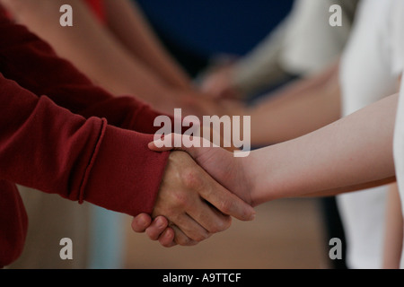 gruppo che tiene le mani e le mani agitando a stretto contatto bambini e adulti bambini in gruppi Foto Stock