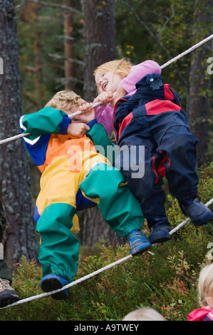 I bambini in un Norvegese naturbarnehage natura vivaio a piedi di corda Foto Stock