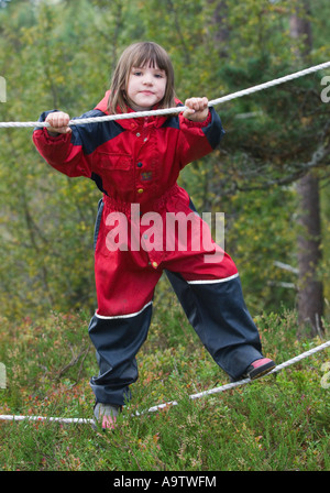 Ragazza in un Norvegese natura naturbarnehage vivaio a piedi di corda Foto Stock