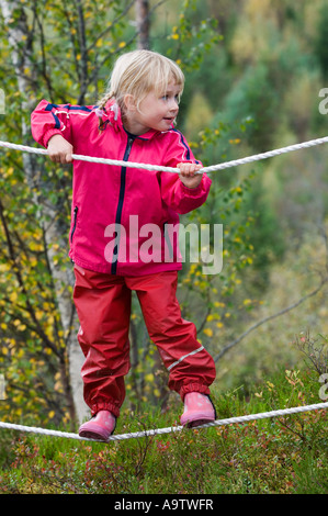 Ragazza in un Norvegese natura naturbarnehage vivaio a piedi di corda Foto Stock