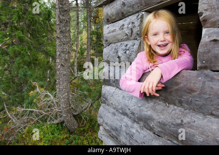 Ragazza in una natura naturbarnehage vivaio guardando fuori della loro cabina nei boschi della Norvegia Foto Stock