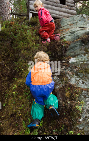 Natura Naturbarnehage vivaio clambering bambini fino una banca nella foresta Foto Stock