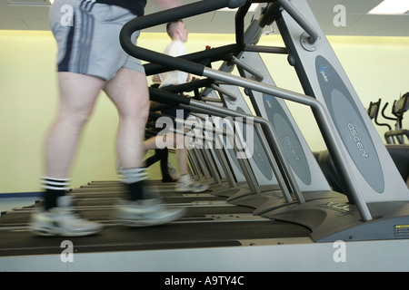 Le persone che usano il tapis roulant in palestra macchine a piedi Foto Stock