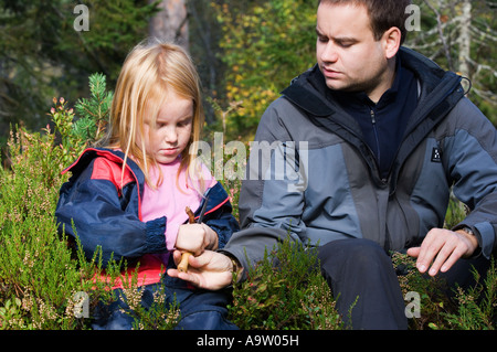 Ragazza in un Norvegese natura naturbarnehage vivaio di imparare a usare un coltello a whittle legno Foto Stock