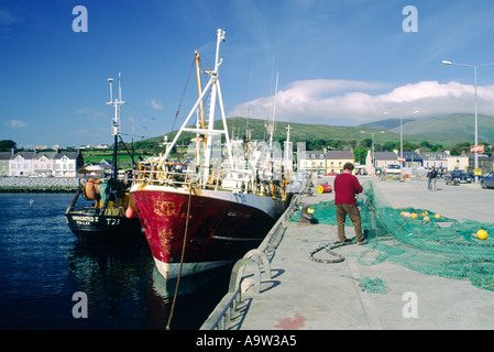 Fisherman riassettavano le reti da pesca accanto a barche da pesca in Dingle Harbour sulla penisola di Dingle, nella contea di Kerry, Irlanda occidentale. Foto Stock