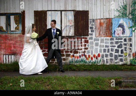 Sposa e lo sposo di fronte graffiti dipinti a muro Foto Stock