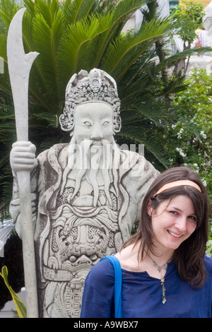 Western tourist in posa di fronte a una statua in Grand Palace Foto Stock