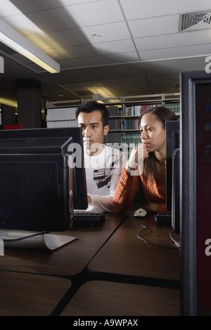 Due studenti universitari che utilizzano il computer nella libreria Foto Stock