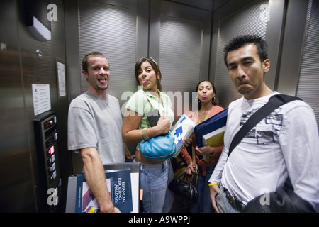 Ritratto di studenti fare facce buffe in un ascensore Foto Stock