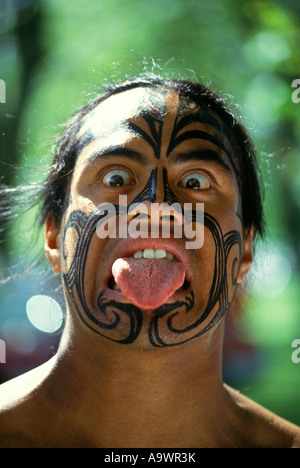 GIOVANE UOMO CHE FA TRADIZIONALE MAORI FACCIA HAKA GUERRA SALUTO ROTORUA ISOLA DEL NORD NUOVA ZELANDA Foto Stock