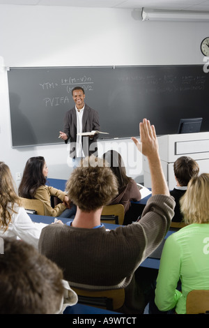Studente alzando la mano in classe Foto Stock