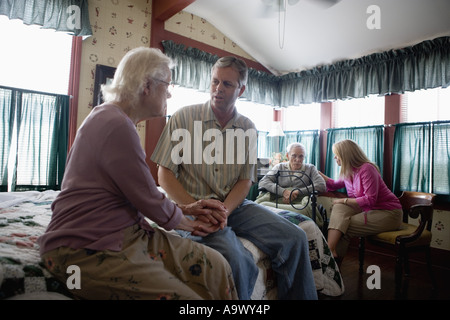 Adulti Bambini in visita e consolante senior genitori in camera da letto Foto Stock