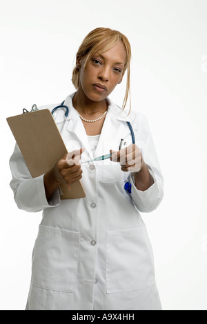 Medico donna in camice bianco e tenendo un clipboard Foto Stock