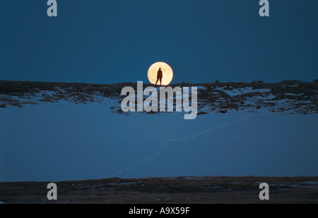 Silhouette di un turista di fronte alla luna piena Altai Russia Foto Stock