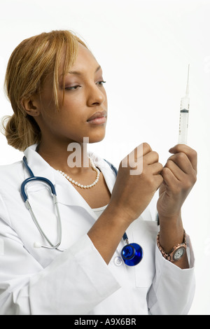 Giovani donne medico preparare una siringa per iniezione Foto Stock