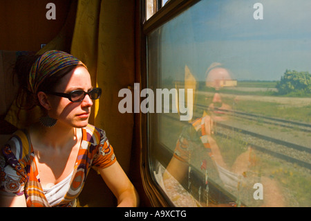 Una ragazza nel suo 20s guardando fuori della finestra del treno in Europa centrale Foto Stock