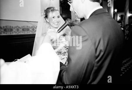 La Polonia, a Lodz, sposa e lo sposo lo scambio di voti nella chiesa, vista laterale (B&W) Foto Stock