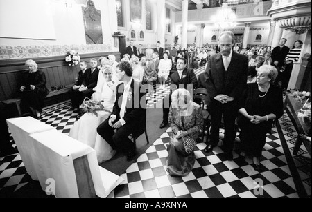 La Polonia, a Lodz, sposa e lo sposo con ospiti di nozze nella chiesa (B&W) Foto Stock
