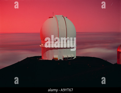 Canada France Hawaii Telescope alla luce della Luna Piena al tramonto con un bagliore rosso nel cielo causato da polvere dal perno di montaggio Foto Stock