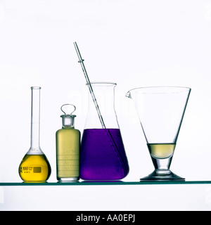 Su uno scaffale sono esposti vari recipienti in vetro da laboratorio contenenti liquidi colorati. Foto Stock