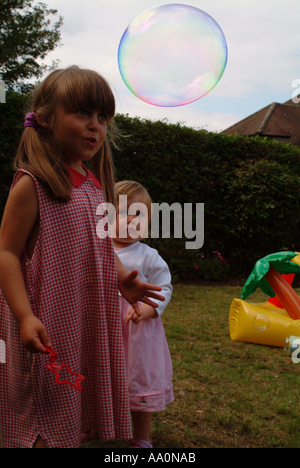 Bambina guardando una bolla gigante Foto Stock