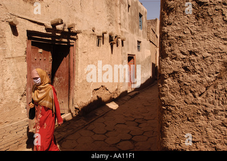 Una donna uigura passeggiate in un vicolo nella parte vecchia di Kashgar nello Xinjiang provincia della Cina Foto Stock