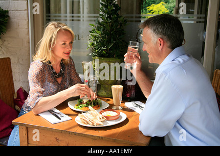 Giovane seduto fuori a pranzo in un ristorante di piccole dimensioni Foto Stock