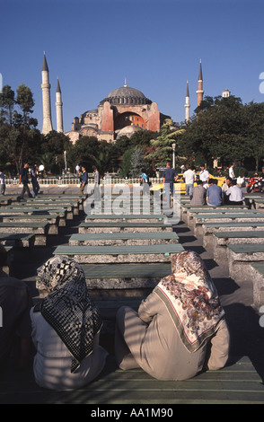 ISTANBUL. Due tradizionalmente-vestito le donne turche seduto e socializzazione su una panchina nel parco di fronte Aya Sofia a Sultanahmet. Foto Stock