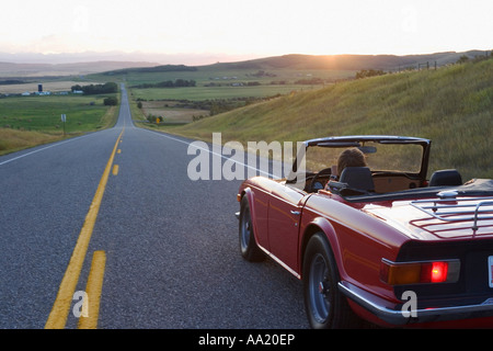 Donna guida su autostrada rurale, Black Diamond, Alberta, Canada Foto Stock