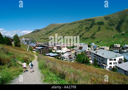 Due escursionisti su un sentiero che conduce al resort, Les Deux Alpes, Francia Foto Stock