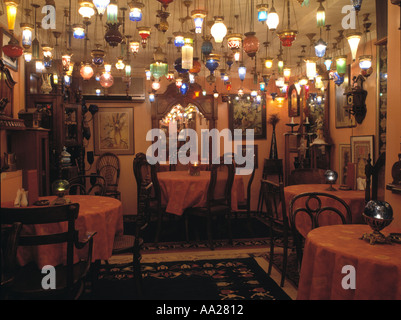 Grande gruppo di vetro illuminato lanterne pendenti dal soffitto nel ristorante turco con sedie antiche a tabelle con panni rosa Foto Stock