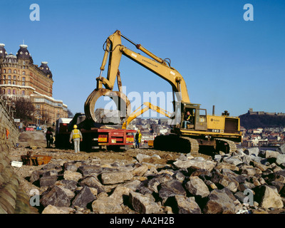 Posizionamento della protezione del masso alla base di una scogliera, Scarborough, North Yorkshire, Inghilterra, Regno Unito. Foto Stock